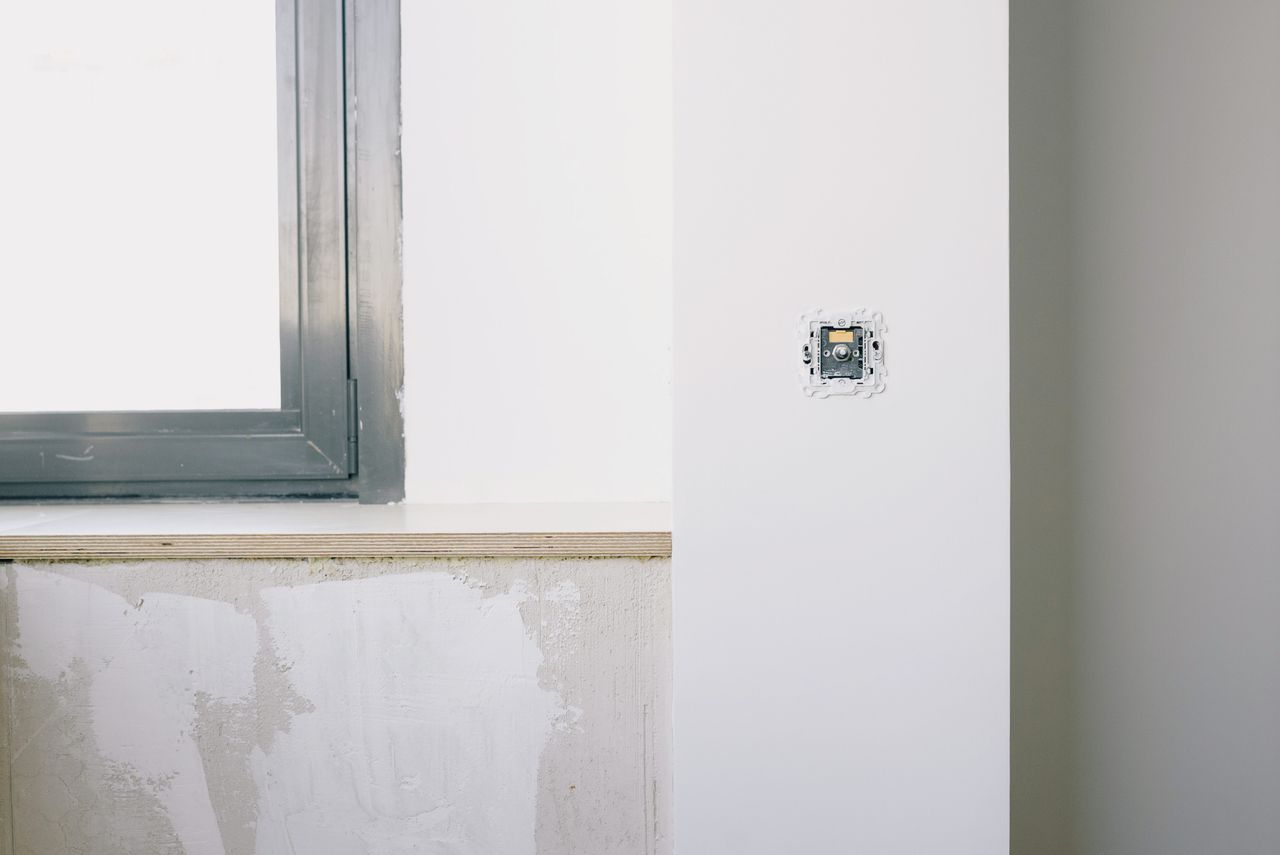 about-us-02 Repairs and installation of new electrical outlet on white wall near window in light apartment