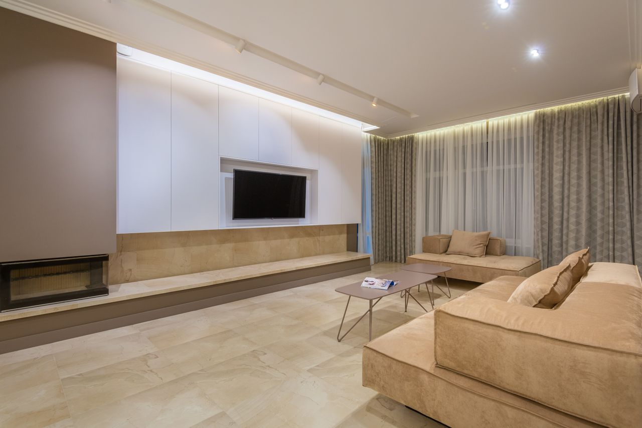 The Art of Drawing Readers In: Your attractive post title goes here Minimalist design of spacious living room with big comfortable beige sofas placed in front of TV in modern apartment with illuminated stretch ceiling